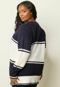 Marinblå och vit randig stickad tröja med lös passform, med ribbad textur och sänkta axlar, som sträcker sig ned till höften.