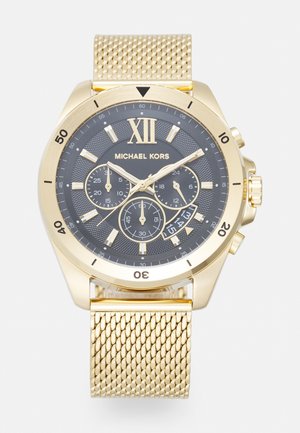 Montre-bracelet Michael Kors en or avec cadran noir, trois sous-cadrans, chiffre romain XII, affichage de la date et bracelet en maille dorée.
