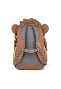 Brauner Rucksack mit Löwenmotiv, ausgestattet mit weichen Ohren, einem gepolsterten Netzrücken, verstellbaren Trägern und seitlichen Fächern für Wasserflaschen.
