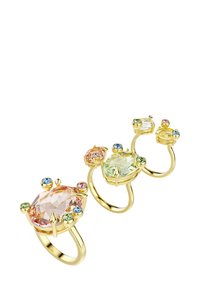 Tre guld ringe prydes af forskellige facetterede ædelsten: en stor pink, en lys grøn og mindre farverige accenter. Glat metalring med detaljerede indstillinger.