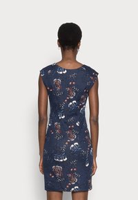 Marinblå blommig klänning med korta axelband, figurnära design och en texturerad tyg med olika blommönster i rött och vitt.