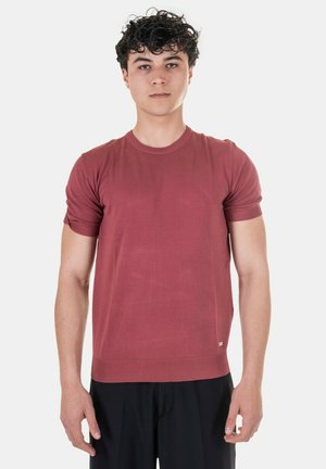 T-shirt rosso a maniche corte in maglia con collo rotondo e polsini a costine. Texture morbida, taglio aderente, branding minimale all'orlo.