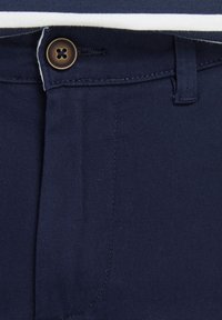 Pantalon bleu marine en twill de coton, avec un seul bouton marron, des plis à l'avant, une passante pour ceinture à la taille et une fermeture éclair.