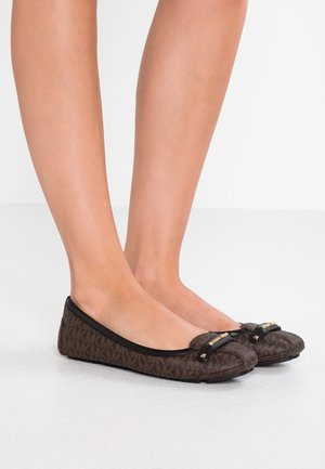 Bruine gebloemde ballerina's met een ronde neus, zwarte rand en een decoratieve strik met hardware-accenten aan de voorkant. Zachte textuur.