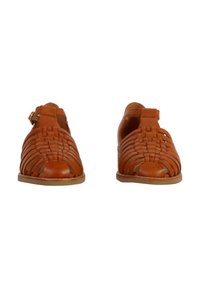 Tan leather sandals with a woven design, open toe, and ankle strap. Flat sole with minimal detailing and a smooth texture.