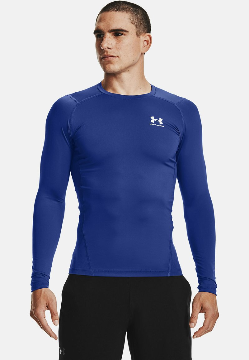 Langærmet sportshem i livligt blå, med en tætsiddende design, glat struktur og subtilt logo på venstre bryst.