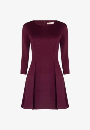 Vestito lungo bordeaux a maniche lunghe con scollatura a cerchio, corpetto sagomato e gonna plissettata. Realizzato in un tessuto liscio e elastico. Dettaglio con zip sul retro.
