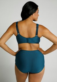 Set bikini a righe teal con reggiseno non imbottito e spalline regolabili, pantaloni a vita alta. Tessuto liscio, materiale elastico.