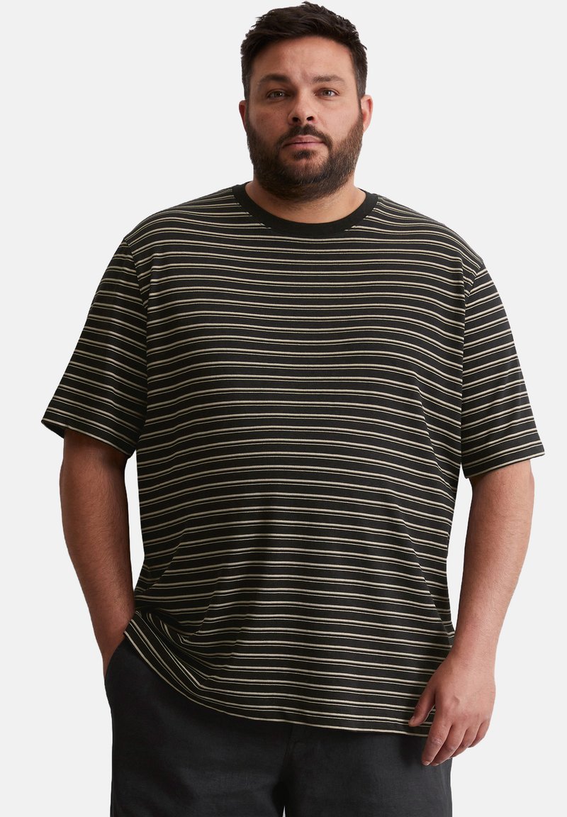 T-shirt à rayures noires et blanches à manches courtes, avec un col rond et une coupe décontractée, fabriqué en tissu doux.