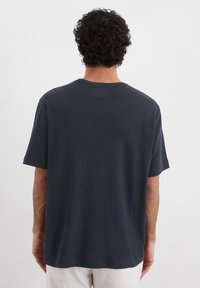Mørkeblå kortermet T-shirt lavet af bomuld, med rund halsudskæring og løs pasform, uden synlige logoer eller grafikker.