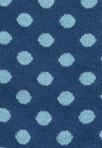 Tessuto blu navy con una texture rigata presenta pois ovali azzurri, distanziati uniformemente sulla superficie in un motivo ripetitivo.