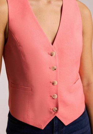Gilet rose avec un décolleté en V profond, des boutons à l'avant et deux poches latérales ; fabriqué dans un tissu lisse avec une coupe ajustée et un ourlet net.