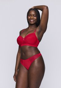 Rode kant lingerie set bestaande uit een gepadded bh met verstelbare bandjes en bijpassende hoge slip, met een gladde, gestructureerde afwerking.