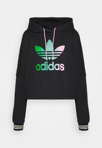 Černá zkrácená mikina s dlouhými rukávy, s barevným logem Adidas a pruhovanými manžetami. Vyrobena z měkké, texturované látky.
