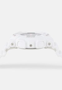 Montre de sport en résine blanche avec un bracelet texturé, un cadran rond et des accents argentés. Elle dispose de boutons surdimensionnés et d'un affichage clair.