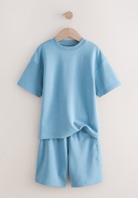 Vaaleansininen shortsit ja niihin sopiva lyhythihainen t-paita, valmistettu pehmeästä, hengittävästä kankaasta, rento istuvuus ilman näkyviä kuvioita tai yksityiskohtia.