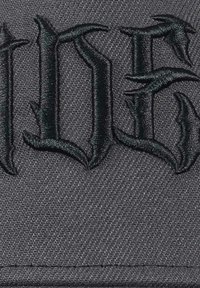 Black cap featuring raised, dark embroidery of ornate text. Material has a textured finish, highlighting the visual impact of the design.