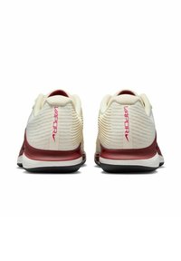 Scarpe sportive bianche e rosse con una tomaia texturizzata, dotate di un logo sul retro, suola in gomma liscia e accenti sul tallone a contrasto.