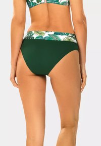 Zielony dół bikini o wysokim kroju, z wzorzystym pasem w białe i zielone liściaste motywy. Gładka tekstura.