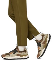 Sneaker marrone e verde con un mix di materiali scamosciati e in rete, caratterizzato da lacci neri, dettagli testurizzati e una suola in gomma spessa.