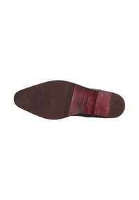 Suela de zapato de cuero marrón con forma puntiaguda. Presenta un logo grabado y un acento rojo en la entresuela, con costuras visibles y detalles de textura.