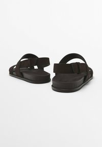 Bruna mockaskinnsandaler med två korsremmar och spänne, med en formad gummisula för komfort och grepp.