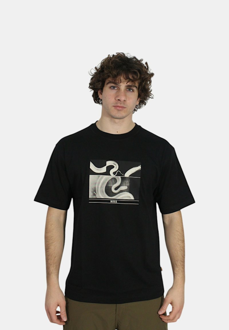 T-shirt nera in cotone con stampa grafica in bianco e grigio, caratterizzata da disegni a spirale e una barra orizzontale con la scritta "BOSS". Maniche corte e collo tondo.