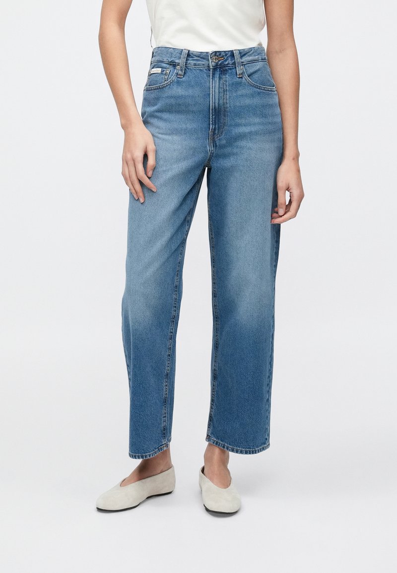 Světle modré džíny s vysokým pasem a volným střihem, s rovným střihem nohavic, pěti kapsami a jemným vyblednutím na stehnech.