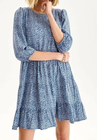 Blaues Blumenmusterkleid mit 3/4 Ärmeln, gerafftem Taillenbereich und Volantsaum, aus einem leichten Stoff mit weicher Textur gefertigt.