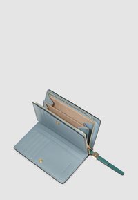 Portafoglio in pelle azzurro chiaro aperto, che mostra molteplici scomparti per carte, un comparto con cerniera per monete, una chiusura a scatto e un cinturino da polso verde con cerniera dorata.