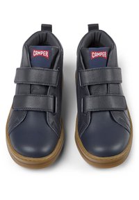 Mornarsko plave cipele s dva Velcro remena, od kože i mrežastog materijala, okruglog vrha, i gumeni đon s bež detaljem. Crveni "Camper" logo na jeziku.