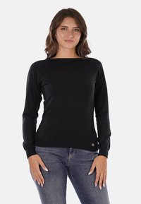 Maglione nero a maglia con maniche lunghe, scollo tondo, polsini e orlo a coste. Presenta un piccolo logo vicino alla vita.