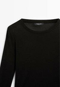 Zwarte lange mouwen shirt met een ronde hals, gemaakt van zachte stof. Heeft een eenvoudig ontwerp, gladde textuur en een subtiele merklabel op de kraag.