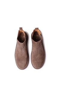 Bottes à enfiler en suède marron avec des panneaux élastiques sur les côtés, des coutures le long de la semelle et une doublure en cuir. Taille 37.