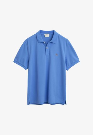 Helles blaues Poloshirt mit weicher Textur, kurzen Ärmeln, einer Knopfleiste mit zwei Knöpfen und kleinem gesticktem Logo auf der Brust. Seitliche Schlitze am Saum.