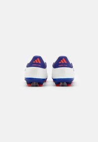 Scarpe da calcio bianche con accenti blu e rossi. Logo "COPA PURE" sul retro. Superfici testurizzate, talloni rinforzati e tacchetti modellati per trazione.