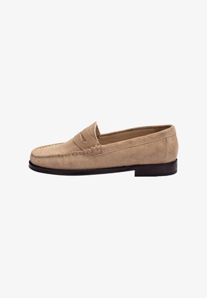 Mocassin pour homme en daim marron clair avec détail de couture apparente et petit talon noir, présenté de profil sur un fond blanc.