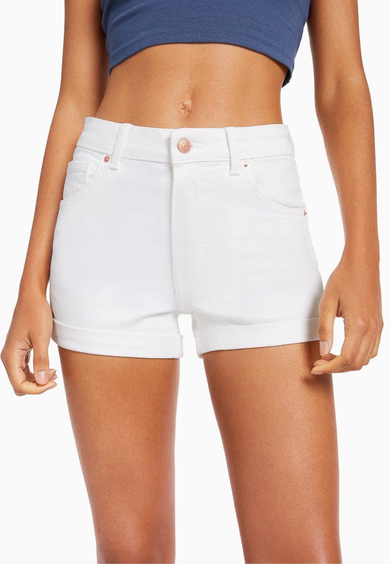 Vita denimshorts med hög midja, uppvikta ärmar, två framfickor och kopparknäppning. Slät textur, skräddarsydd passform.
