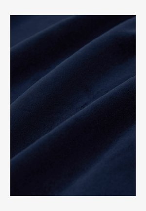 Granatowy aksamit z miękką, teksturowaną powierzchnią, z delikatnymi falami i gładkim połyskiem, idealny do tapicerki lub zastosowań modowych.