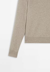 Hellbeiger Pullover mit langen Ärmeln, aus weichem Strickmaterial, mit geripptem Saum und Bündchen, minimalistischem Design und glatter Textur.