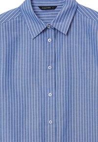Camicia a righe blu con colletto classico, apertura frontale con bottoni e bottoni blu chiaro leggermente texturizzati. Righe bianche verticali su tutta la camicia.
