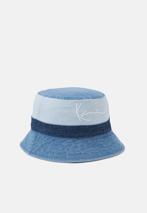 Kapelusz typu bucket z denimu z jasnoniebieskimi i ciemnoniebieskimi panelami, z ciemnoniebieską opaską i białym wyszywanym logo po boku.