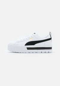 Sneakers bianche con suola a piattaforma spessa, caratterizzate da una striscia nera e accenti neri. Logo "PUMA" dorato sul lato e un pannello texturizzato.