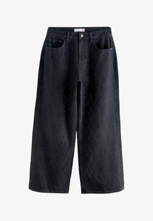 Jeans negros de pierna ancha con patrón acolchado en forma de diamante y detalles de remaches metálicos, botón frontal y diseño de cinco bolsillos.