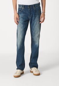 Blauwe denim jeans met een rechte pijp, voorzien van een gemiddelde wassing, subtiele vervaging, vijf zakken en een tailleband met lussen voor een riem.