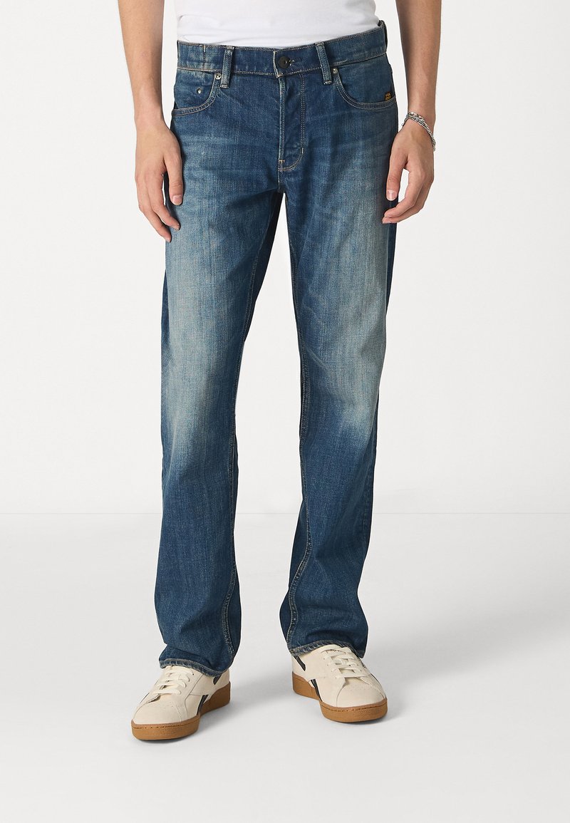 Blauwe denim jeans met een rechte pijp, voorzien van een gemiddelde wassing, subtiele vervaging, vijf zakken en een tailleband met lussen voor een riem.