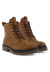 Ruske nahkasaappaat nilkkojen ylle mustilla nauhoilla, pyöreällä varvaskärjellä ja kumipohjalla. Varusteena teksturoidut pinnat ja vetonauhat takana.