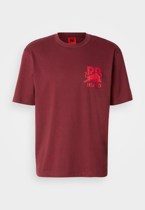 Burgundijska pamučna majica s okruglim izrezom, kratkim rukavima i crvenim grafičkim dizajnom s bikom i tekstom na lijevoj strani prsnog područja.