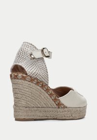 Klinové espadrilky, bílá kožená svrchní část s tkaným vzorem, nastavitelné pásky kolem kotníku, pata omotaná juty, texturovaná béžová podrážka, přírodní akcenty.