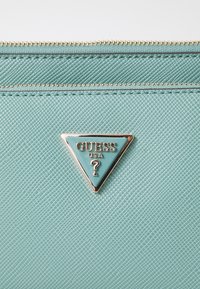 Guess NOELLE POUCH CROSSBODY - Skuldertasker - turquoise